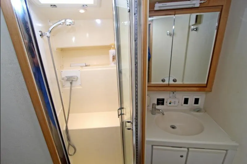  Yacht Photos Pics Bathroom interior of a 1994 Bertram 50 Convertible yacht, featuring a shower and sink.