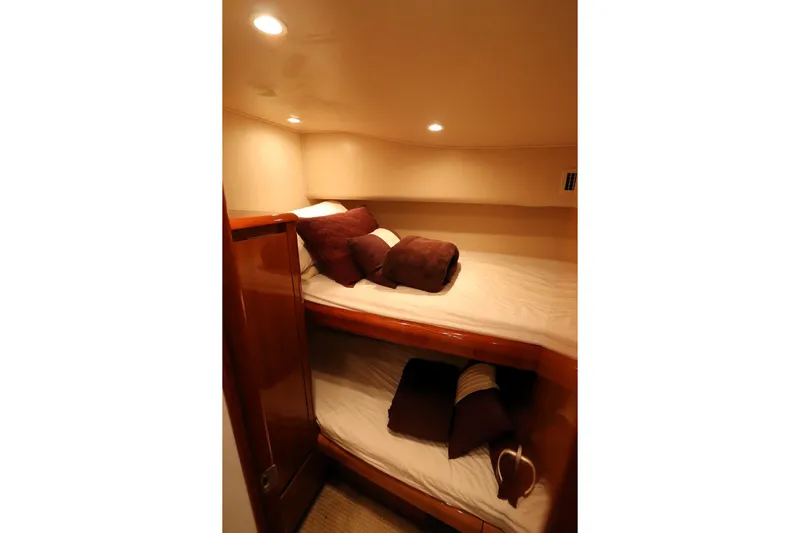 Juris Tantrum Yacht Photos Pics Cozy cabin interior of 2011 Viking 46 Convertible yacht with bunk beds and soft lighting.