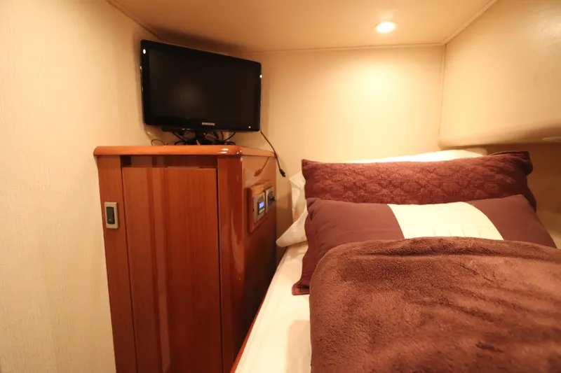 Juris Tantrum Yacht Photos Pics Cozy cabin interior of 2011 Viking 46 Convertible yacht with TV and plush bedding.