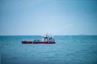 Red C.P.N Pelikan boat spraying water in the ocean, 2024 model.