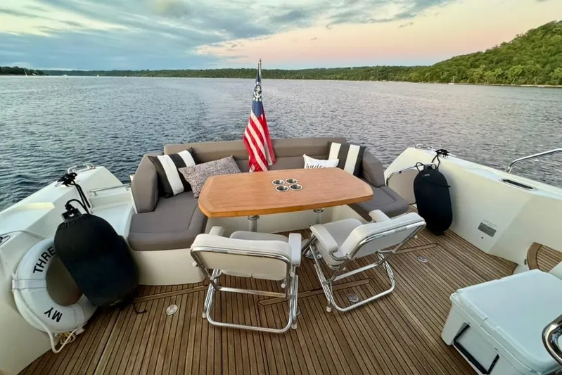 My Three Es Yacht Photos Pics Luxury seating area on 2016 Prestige 500 S yacht, overlooking serene waters at sunset.