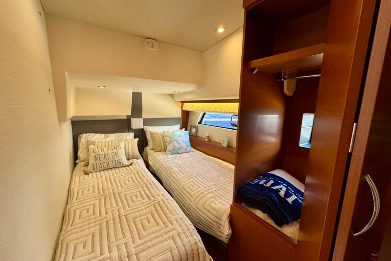 My Three Es Yacht Photos Pics Twin cabin interior of 2016 Prestige 500 S yacht with cozy bedding and wooden cabinetry.