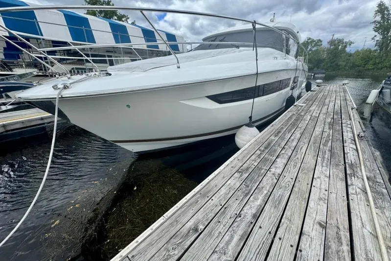 My Three Es Yacht Photos Pics 2016 Prestige 500 S yacht docked beside a wooden pier under cloudy skies.