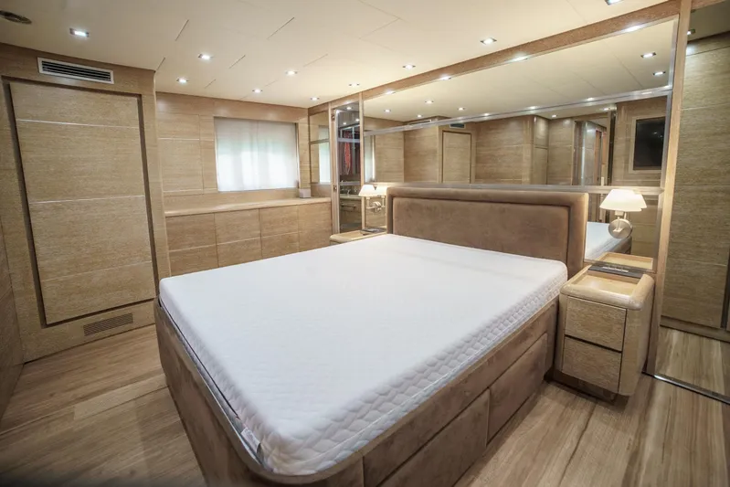 Ganache Yacht Photos Pics Luxurious bedroom interior on a 2005 Leopard 24 yacht, featuring elegant wood finishes and ambient lighting.