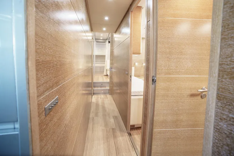 Ganache Yacht Photos Pics Narrow hallway inside a 2005 Leopard 24 yacht with wooden paneling and modern lighting.