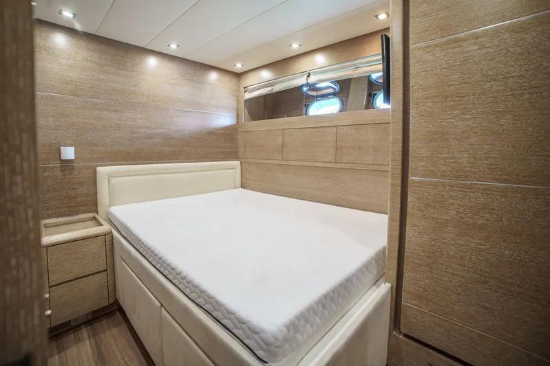 Ganache Yacht Photos Pics Luxurious bedroom interior on 2005 Leopard 24 yacht, featuring elegant wood paneling and ambient lighting.