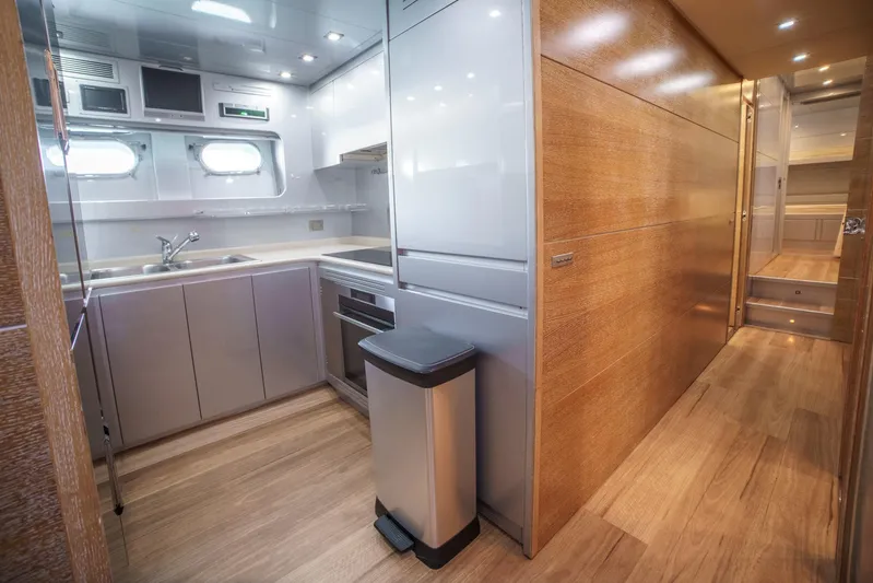 Ganache Yacht Photos Pics Modern kitchen interior on a 2005 Leopard 24 yacht, featuring sleek cabinetry and wood flooring.