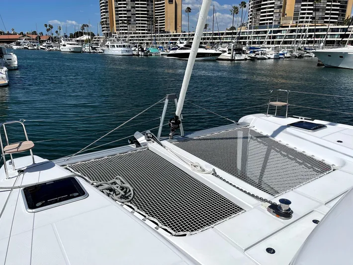 Ariella Yacht Photos Pics 2021 Lagoon 42 catamaran docked in a marina with cityscape background.