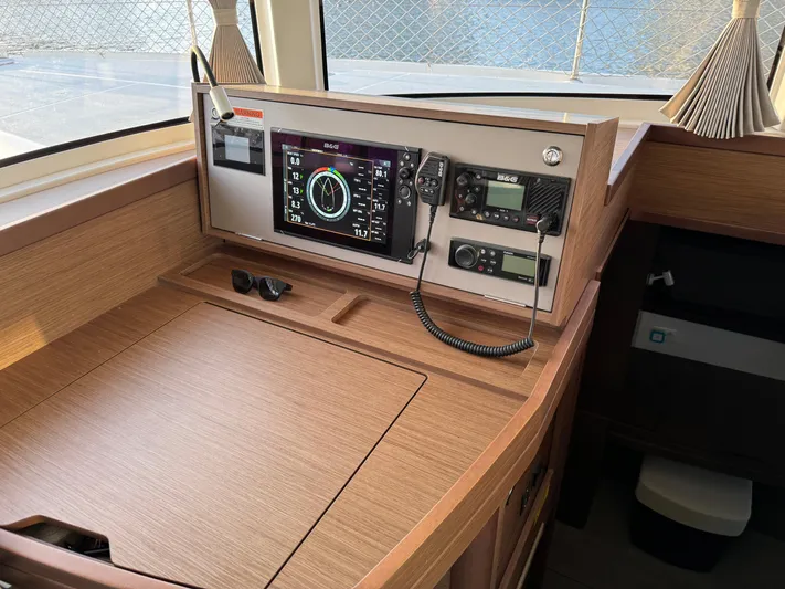 Ariella Yacht Photos Pics Navigation station of 2021 Lagoon 42 catamaran with modern instruments and wooden finish.
