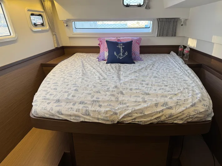 Ariella Yacht Photos Pics Luxurious cabin interior of 2021 Lagoon 42 catamaran with nautical-themed bedding.