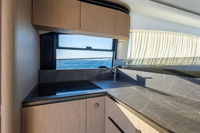 Mask Yacht Photos Pics Luxurious kitchen interior of 2023 Azimut 53 yacht with ocean view through window.