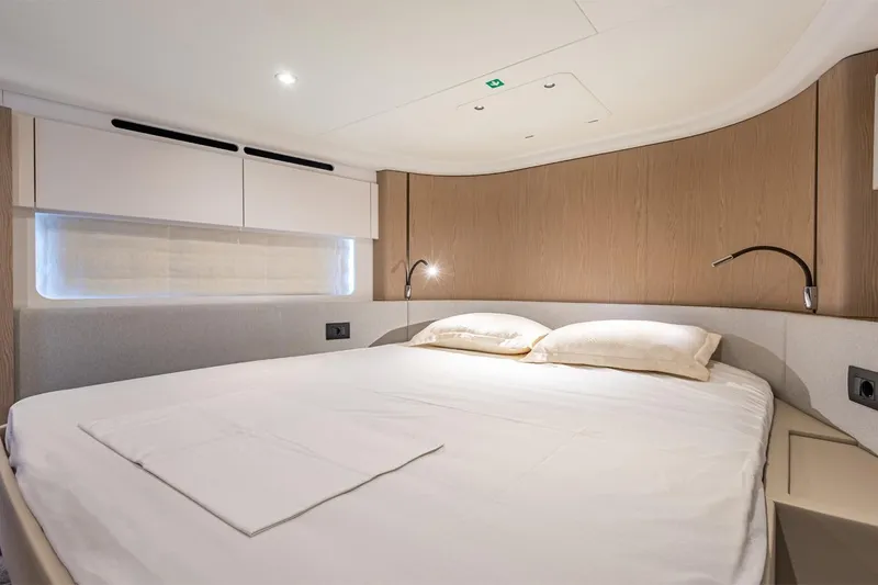 Mask Yacht Photos Pics Luxurious bedroom interior of 2023 Azimut 53 yacht with modern design and cozy bedding.