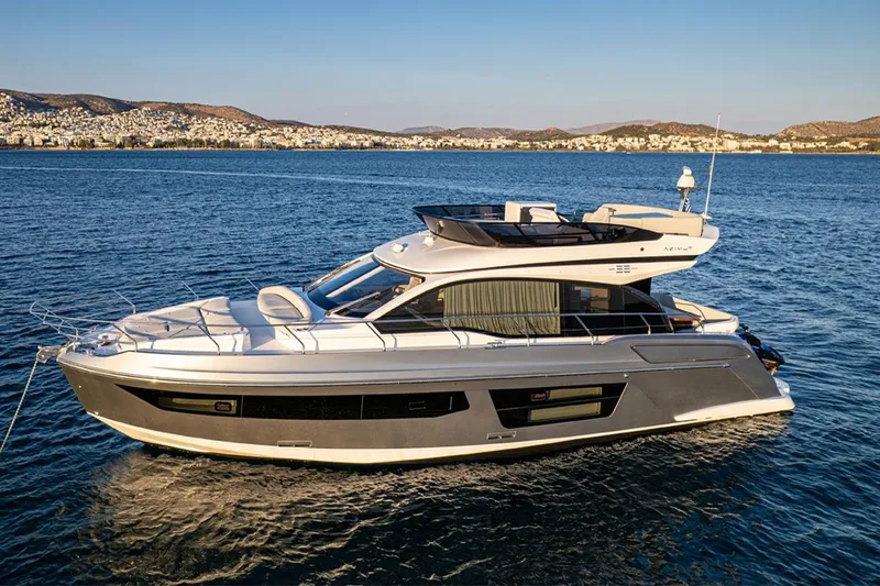 Mask Yacht Photos Pics 2023 Azimut 53 yacht cruising on serene blue waters near a coastal city.