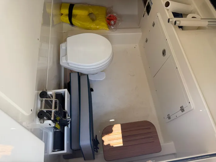  Yacht Photos Pics 2024 Boston Whaler 330 Outrage interior with toilet, life jacket, and storage compartments.