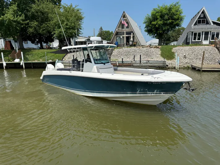  Yacht Photos Pics 2024 Boston Whaler 330 Outrage boat docked near waterfront homes.