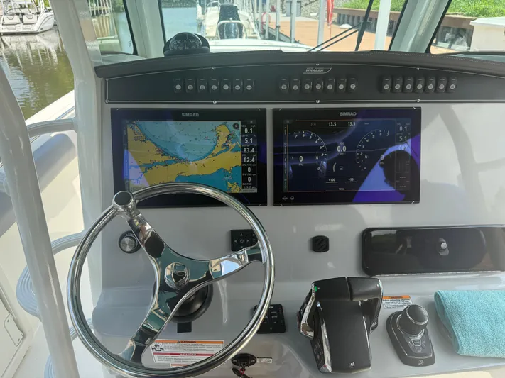 Yacht Photos Pics 2024 Boston Whaler 330 Outrage helm with dual Simrad displays and steering wheel.