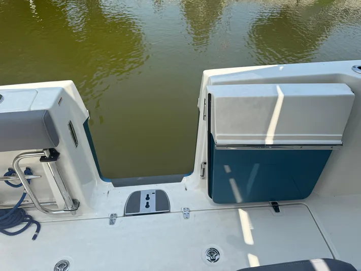  Yacht Photos Pics 2024 Boston Whaler 330 Outrage boat with open transom door, docked on calm water.