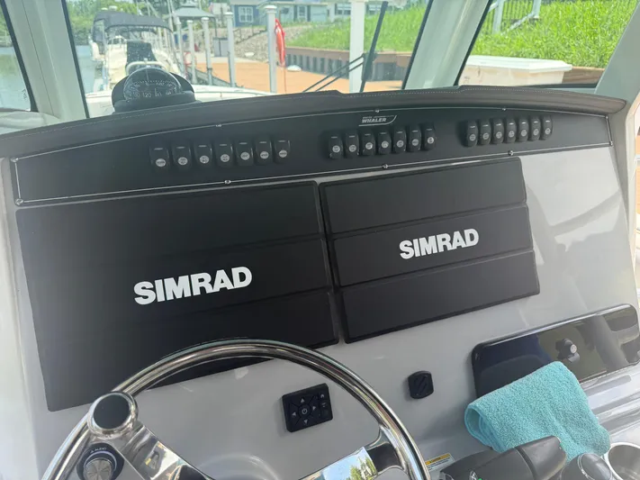  Yacht Photos Pics 2024 Boston Whaler 330 Outrage helm with dual Simrad displays and steering wheel.