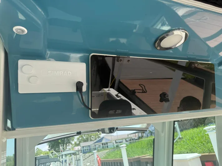  Yacht Photos Pics 2024 Boston Whaler 330 Outrage dashboard with Simrad electronics and sleek blue finish.