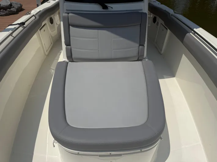  Yacht Photos Pics 2024 Boston Whaler 330 Outrage boat interior with gray cushioned seating.