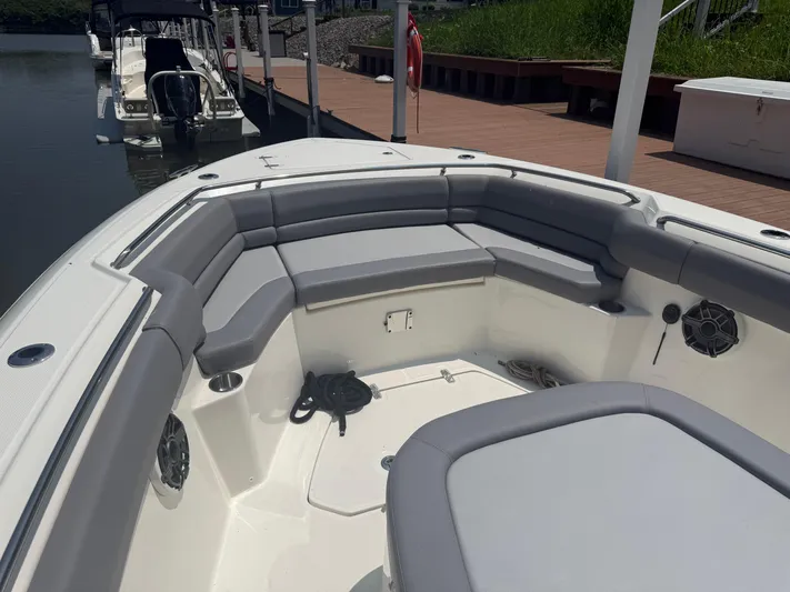  Yacht Photos Pics 2024 Boston Whaler 330 Outrage boat interior with cushioned seating and docked at marina.