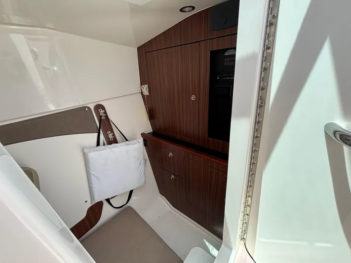  Yacht Photos Pics 2017 Pursuit DC 325 Dual Console cabin interior with wood paneling and storage.