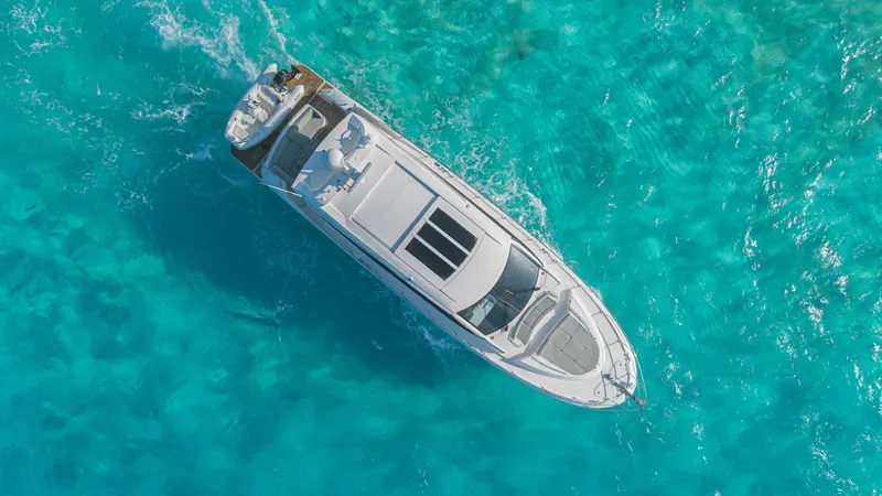 Wallys World Yacht Photos Pics Aerial view of 2017 Sea Ray L590 yacht cruising in clear turquoise waters.