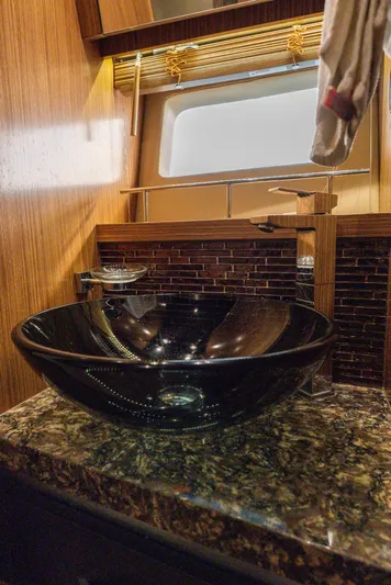 Wallys World Yacht Photos Pics Luxurious bathroom sink in 2017 Sea Ray L590 yacht, featuring elegant black basin and granite countertop.