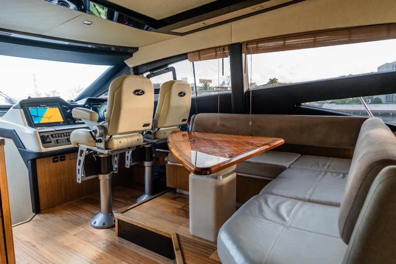 Wallys World Yacht Photos Pics Luxurious interior of 2017 Sea Ray L590 yacht with helm, seating, and wooden table.