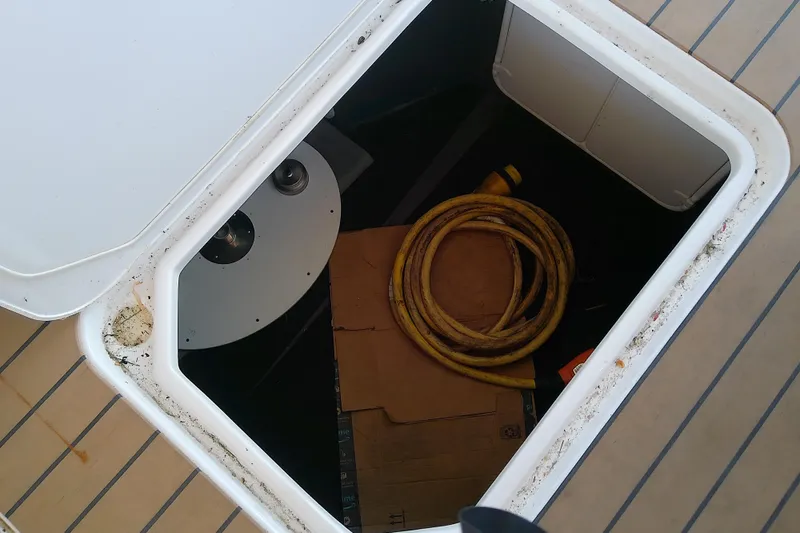  Yacht Photos Pics Open storage compartment on 2019 Floe Craft 3950C Aquafina boat with coiled yellow hose.