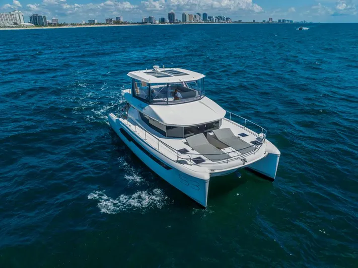 Breathe Yacht Photos Pics 2020 Leopard 53 Powercat cruising on blue ocean near city skyline.