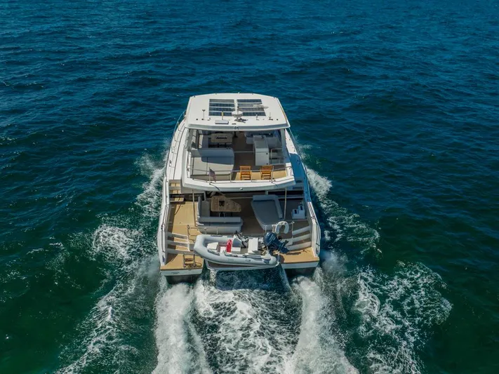 Breathe Yacht Photos Pics 2020 Leopard 53 Powercat cruising on open sea, rear view.