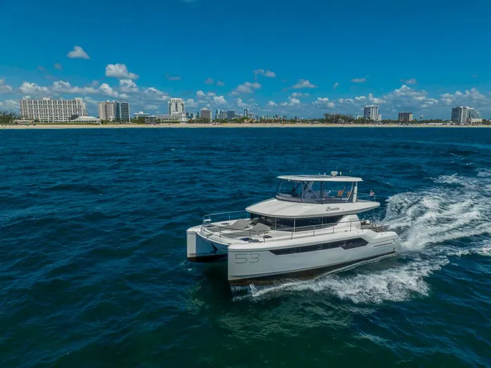 Breathe Yacht Photos Pics 2020 Leopard 53 Powercat cruising on ocean near city skyline.