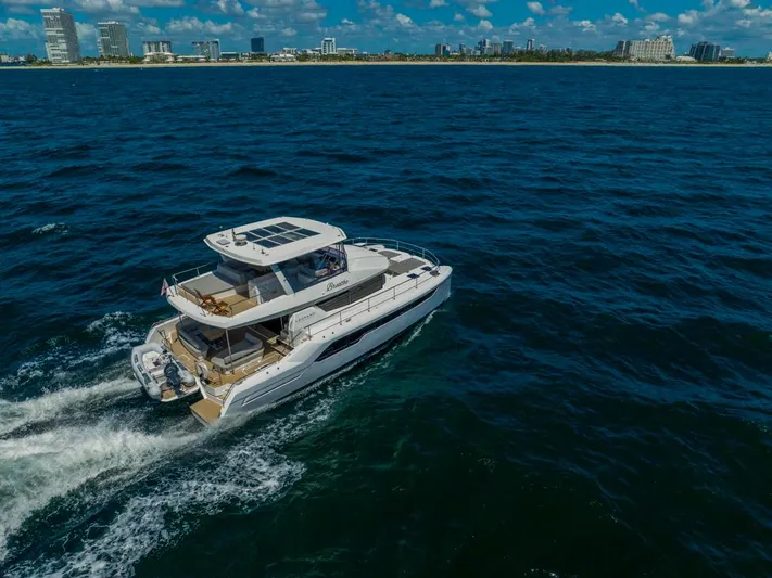 Breathe Yacht Photos Pics 2020 Leopard 53 Powercat cruising on ocean near city skyline.