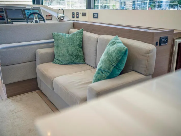 Breathe Yacht Photos Pics Interior of 2020 Leopard 53 Powercat with beige sofa and green cushions.