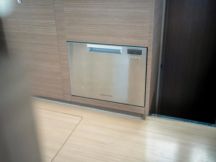 Breathe Yacht Photos Pics Built-in dishwasher on Leopard 53 Powercat yacht, 2020 model, with wood paneling.