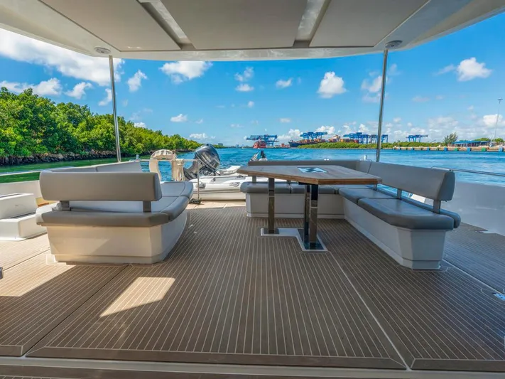 Breathe Yacht Photos Pics Leopard 53 Powercat 2020 yacht deck with seating and table, overlooking scenic waterway.