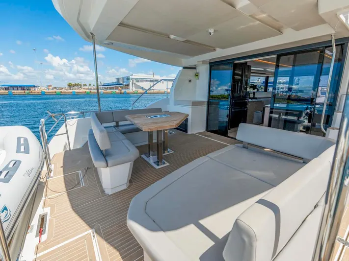 Breathe Yacht Photos Pics Leopard 53 Powercat 2020 yacht deck with seating and table, overlooking water.