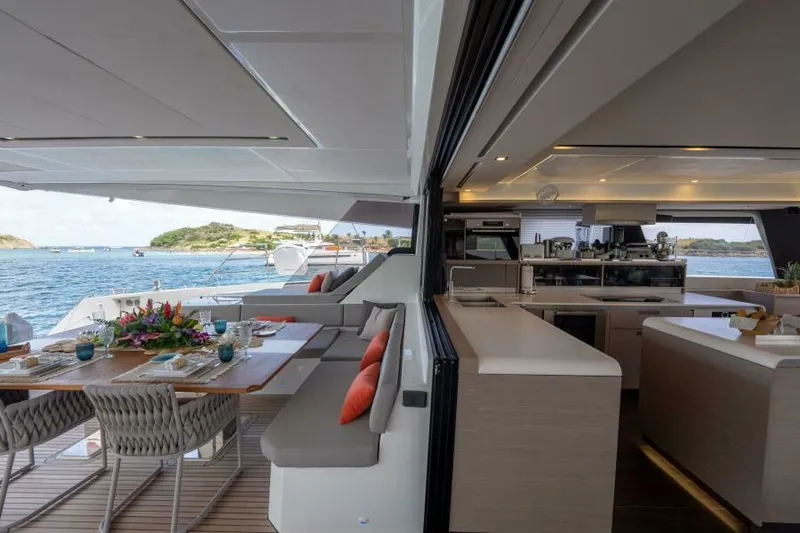 Roamance Yacht Photos Pics Luxurious 2022 Fountaine Pajot Alegria 67 yacht interior with elegant dining and kitchen area.