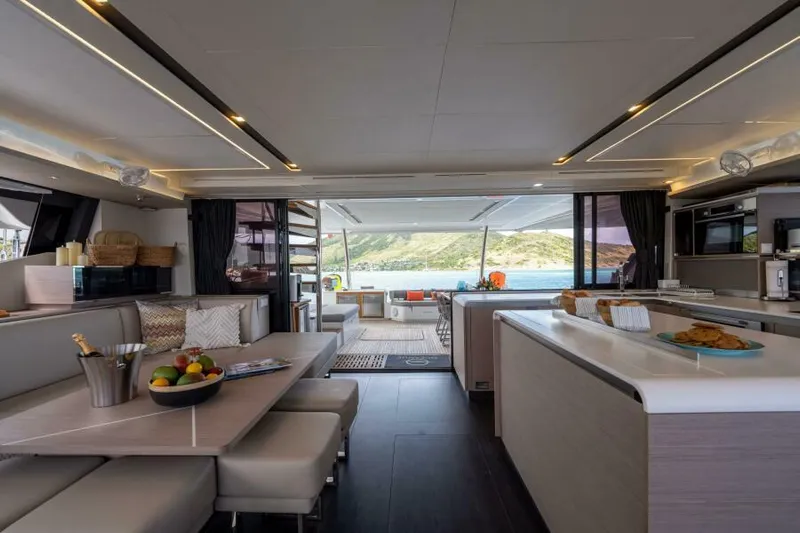 Roamance Yacht Photos Pics Luxurious interior of 2022 Fountaine Pajot Alegria 67 yacht with modern dining and kitchen area.