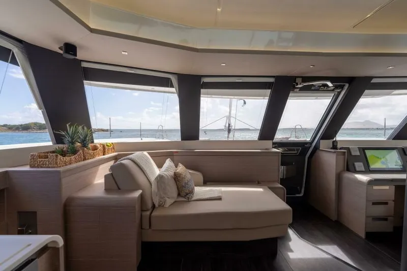 Roamance Yacht Photos Pics Luxurious interior of 2022 Fountaine Pajot Alegria 67 yacht with panoramic windows and elegant seating.