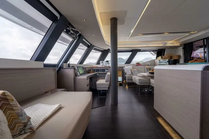 Roamance Yacht Photos Pics Luxurious interior of 2022 Fountaine Pajot Alegria 67 yacht with modern seating and panoramic windows.