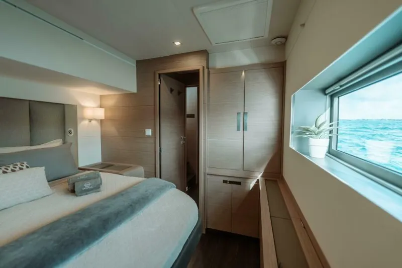 Roamance Yacht Photos Pics Luxurious bedroom interior of 2022 Fountaine Pajot Alegria 67 yacht with ocean view.