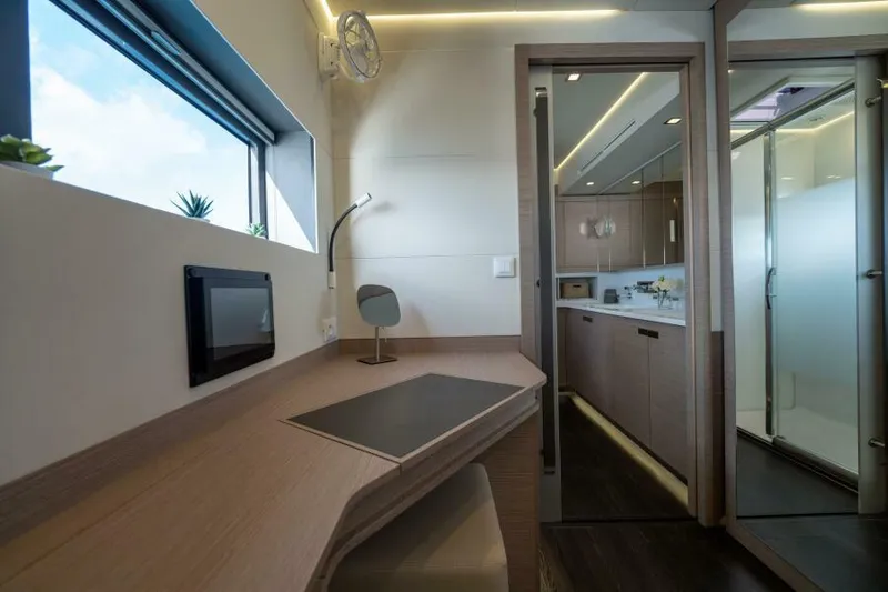 Roamance Yacht Photos Pics Luxurious interior of 2022 Fountaine Pajot Alegria 67 yacht with modern desk and kitchenette.