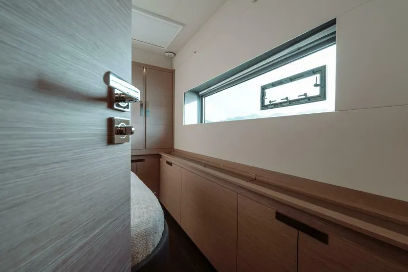 Roamance Yacht Photos Pics Interior of 2022 Fountaine Pajot Alegria 67 yacht, featuring sleek wood finishes and a large window.