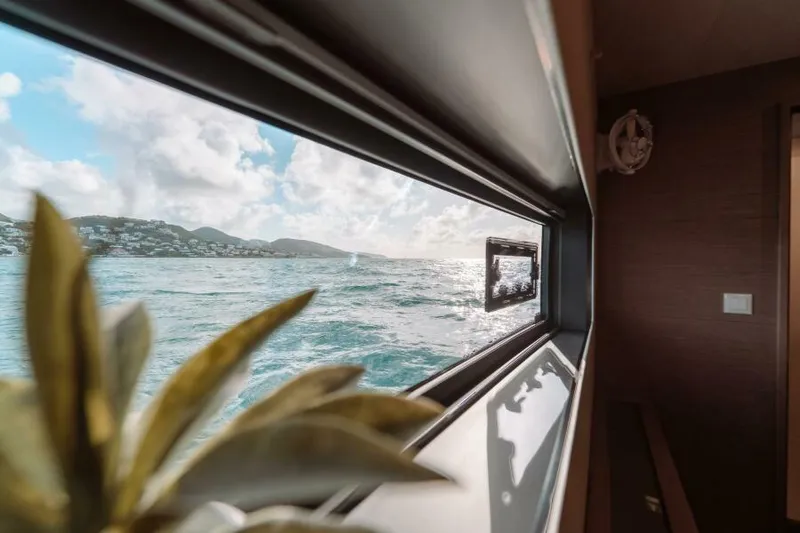 Roamance Yacht Photos Pics View from Fountaine Pajot Alegria 67 yacht window, overlooking ocean and distant hills, 2022 model.