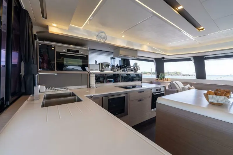Roamance Yacht Photos Pics Modern kitchen interior on 2022 Fountaine Pajot Alegria 67 yacht, featuring sleek design and appliances.
