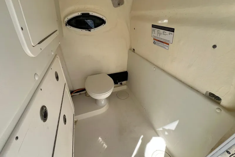  Yacht Photos Pics 2024 World Cat 325 CC boat interior with compact marine toilet and storage compartments.