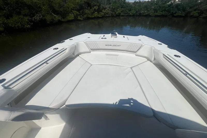  Yacht Photos Pics 2024 World Cat 325 CC boat with spacious seating, docked on a calm river.