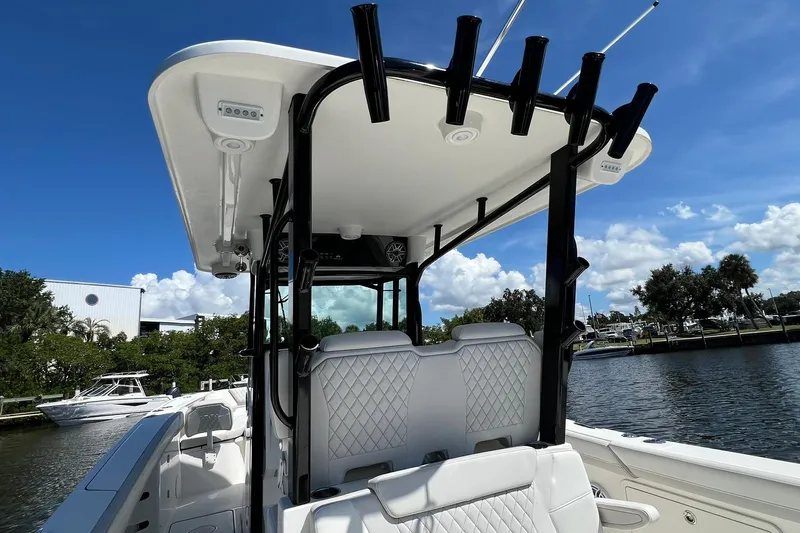  Yacht Photos Pics 2024 World Cat 325 CC boat interior with rod holders, white seating, and sunny waterfront view.